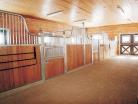 Medium shot of tuscany horse stalls with silver finials and feed openings