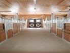 Aisle view of multiple Tuscany horse stalls