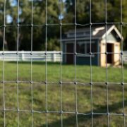 Non-Climb Galvanized Mesh Fence with a small out building in the background