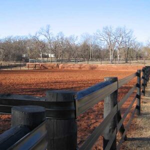 brown fence on the edge of a red dirt field