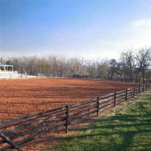 brown fence on the edge of a red dirt field