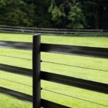 3 rails of black 525 flex fence in the foreground of a green field with the fence continuing in the background.