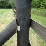 close up of a brown fence rail attached to a wooden post