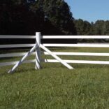 a photo of the corner of a white 4 rail fence
