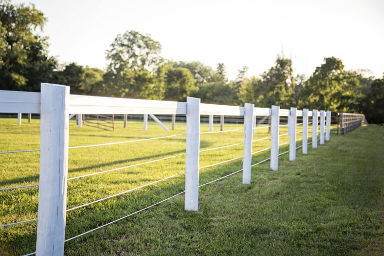 Combination 07 white fence installed on wooden white post in a filed with sunlight
