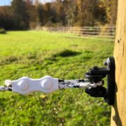 a single strand of white and black braided electric fence connected to a wooden post