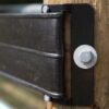 extreme closeup from above a a brown end plate attached to a wood post
