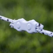 a strand of white and black braided electric fence joined with a white connector