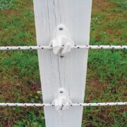 white and black braided electric fencing installed on a white fence post