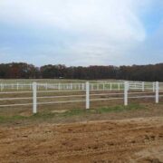 white electric tape in a large field installed on white posts