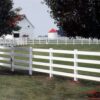 white fence in front of a white barn