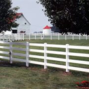 white fence in front of a white barn