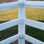 tensioners holding tape inside a pvc white fence