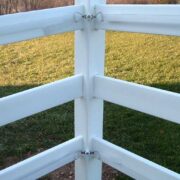 tensioners holding tape inside a pvc white fence