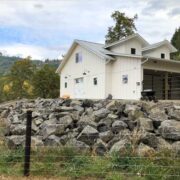 coated wire fence with a large white barn behind it