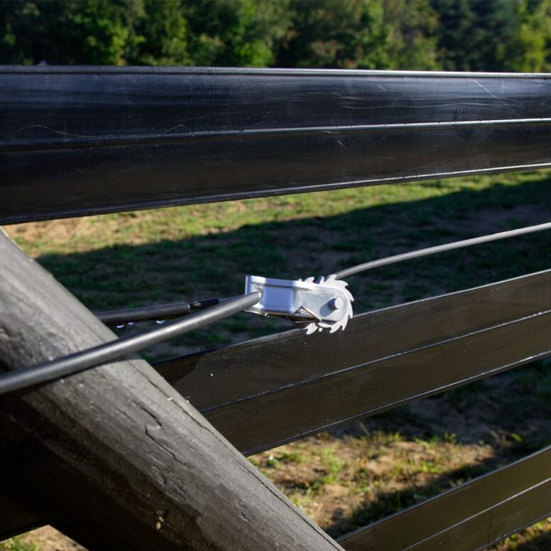 RTE_20.jpg fence tensioner holding coated wire tight between two rails of black flex fence