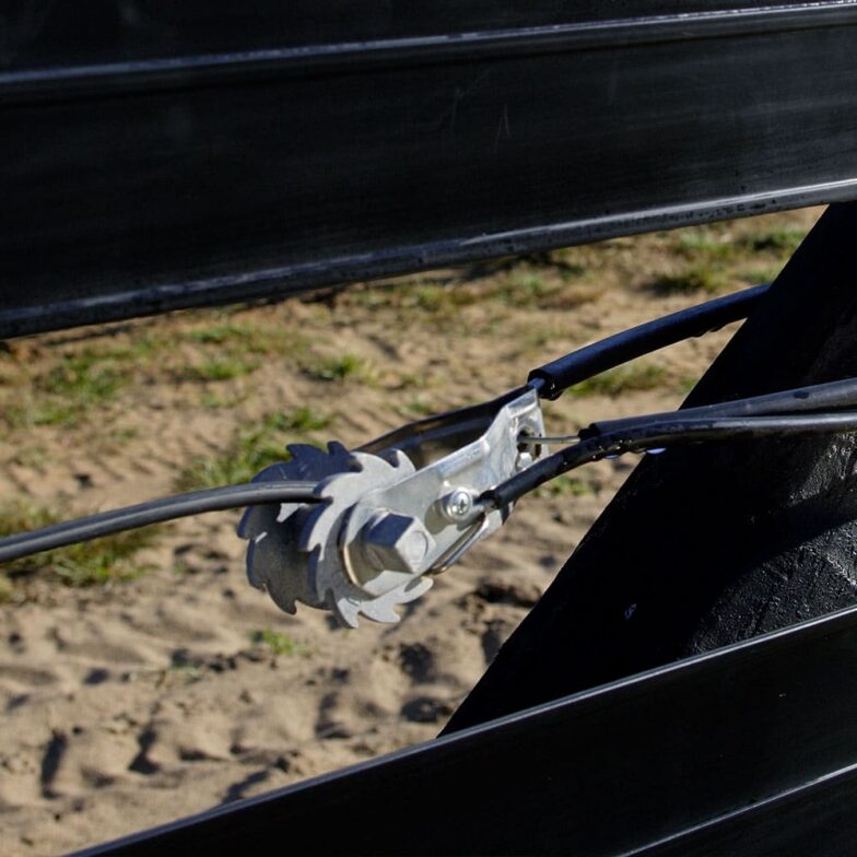 RTE_21.jpg fence tensioner holding coated wire tight between two rails of black flex fence